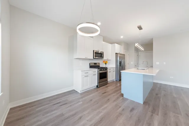a kitchen with granite countertop a stove a sink and a refrigerator