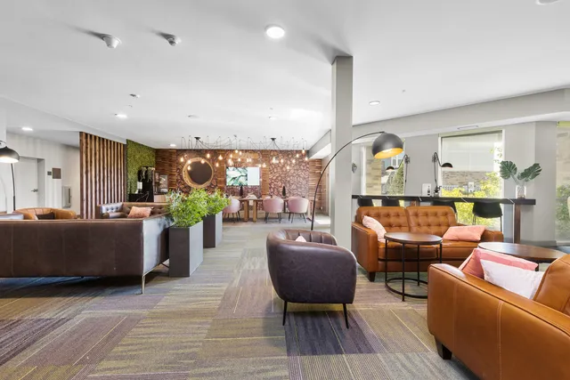 a living room with furniture and paintings on the wall next to a window