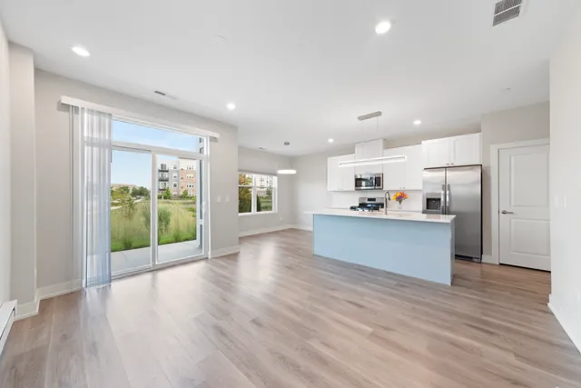 a view of kitchen with refrigerator and wooden floor