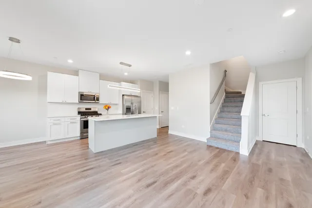 a view of kitchen with wooden floor and electronic appliances