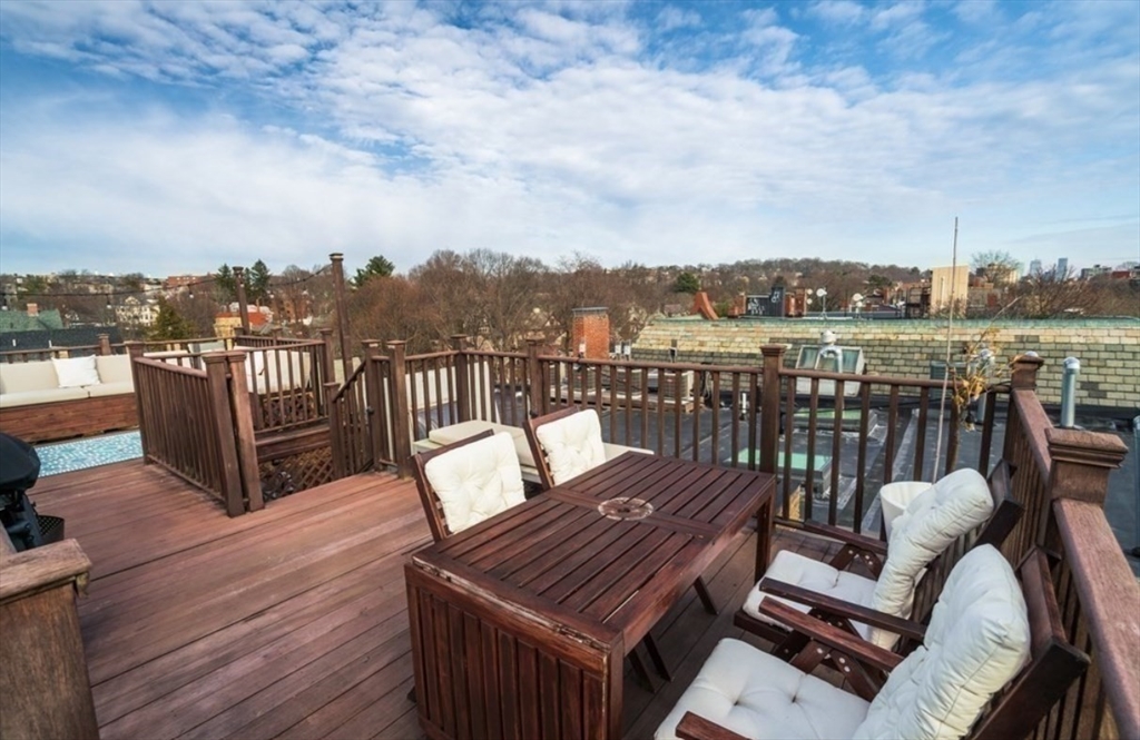 1778 Beacon Street, Unit 302 Brookline, MA 02445 - Photo 17 of 18 a view of a balcony with wooden floor table and chairs