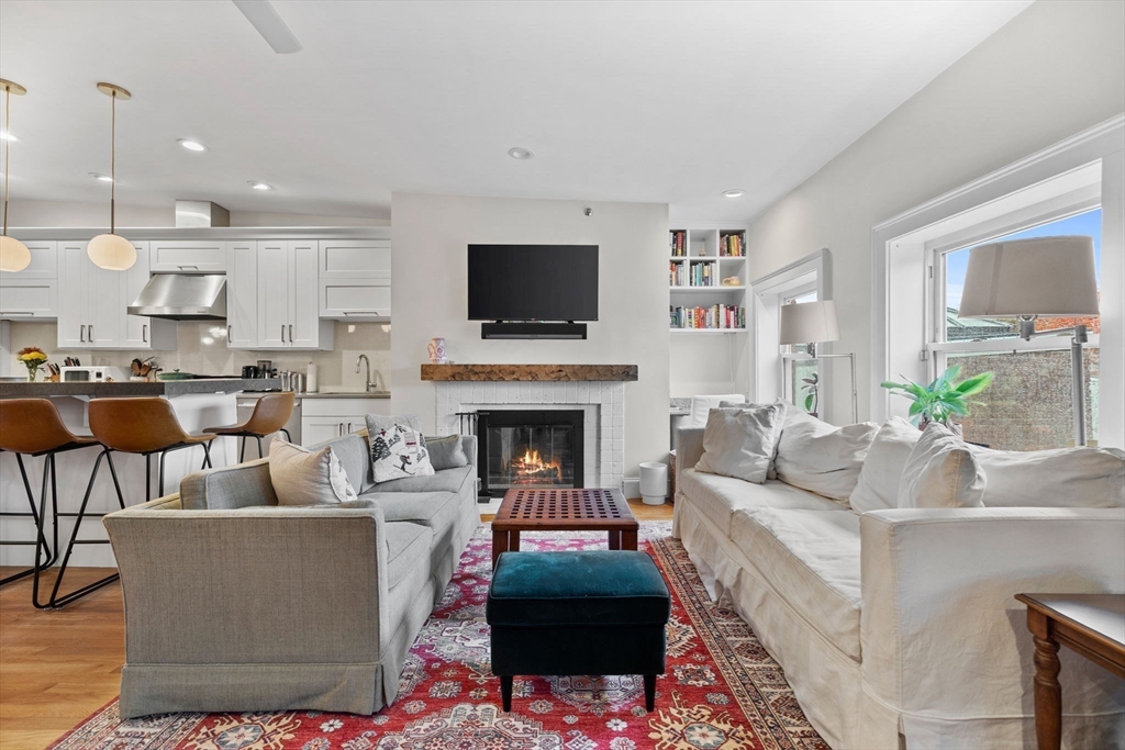 1778 Beacon Street, Unit 302 Brookline, MA 02445 - Photo 7 of 18 a living room with furniture a flat screen tv and a fireplace