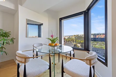 a kitchen with stainless steel appliances granite countertop a sink a stove a refrigerator cabinets and chairs