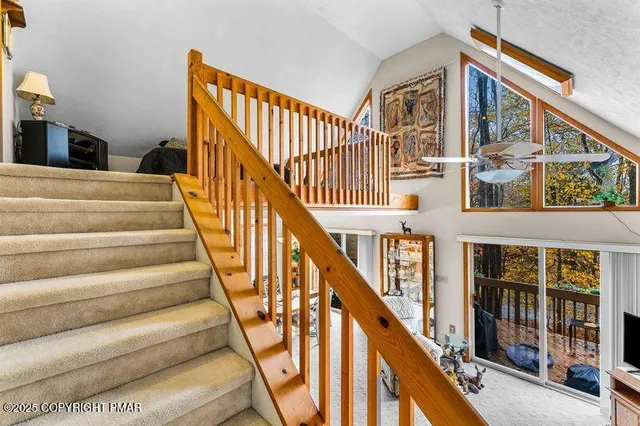 a view of staircase with lots of frames on wall and a large window