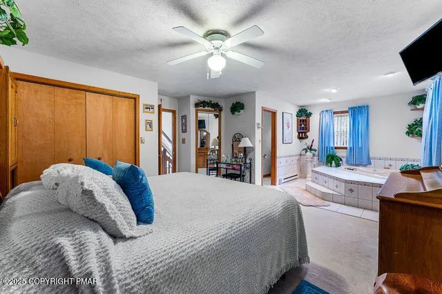 a spacious bedroom with a tub and large windows