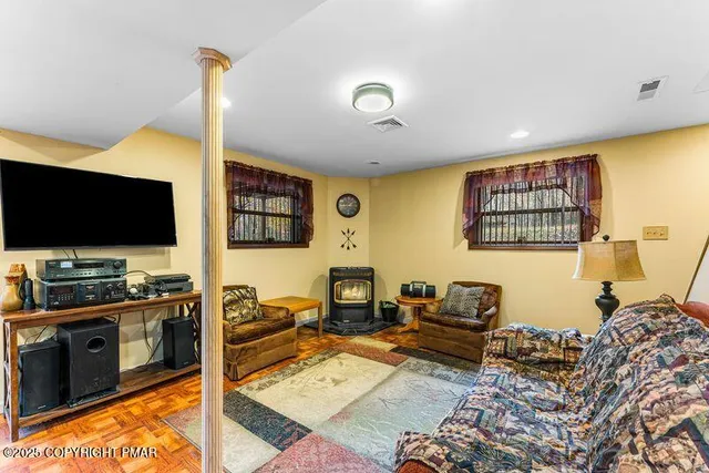 a living room with furniture stove and large window