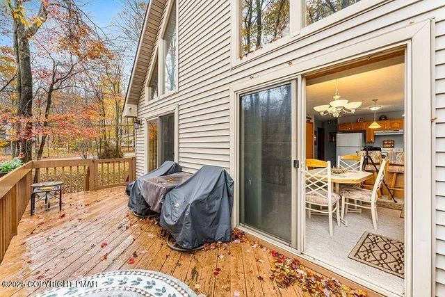 a view of a swimming pool with a patio and wooden fence