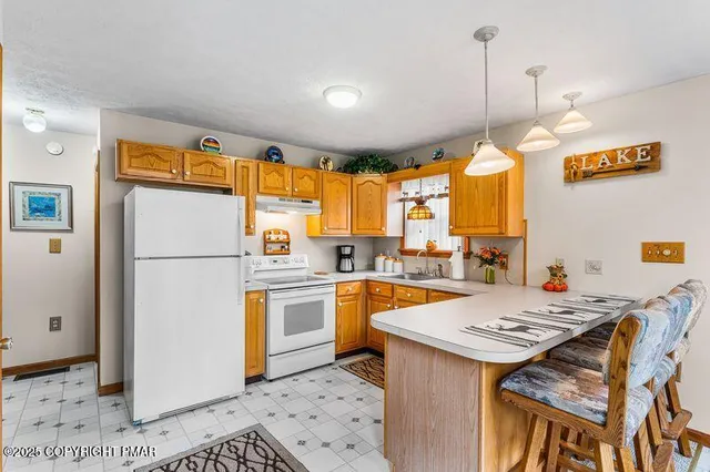 a kitchen with a refrigerator a stove a sink dishwasher and a dining table with wooden floor