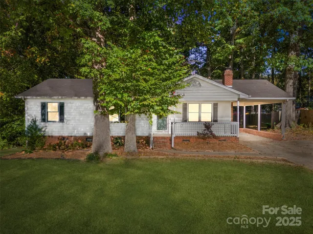 a front view of a house with a yard and trees