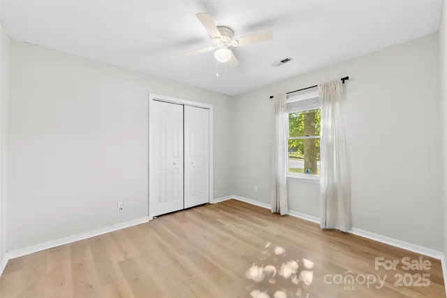 an empty room with fan and a window