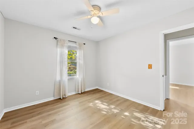 an empty room with closet and a chandelier fan