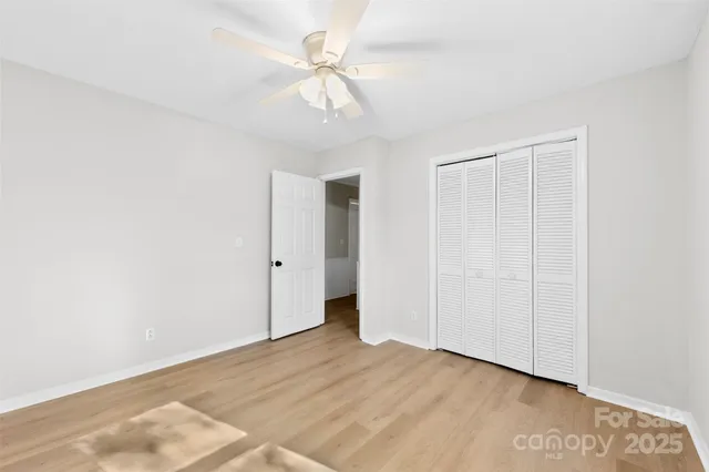 an empty room with a ceiling fan and a window