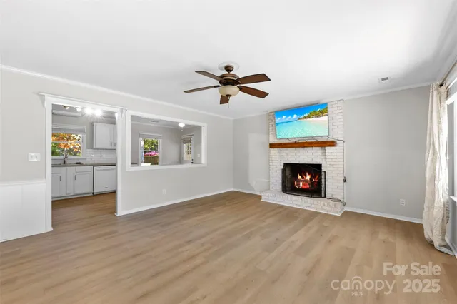 an empty room with fireplace and a ceiling fan