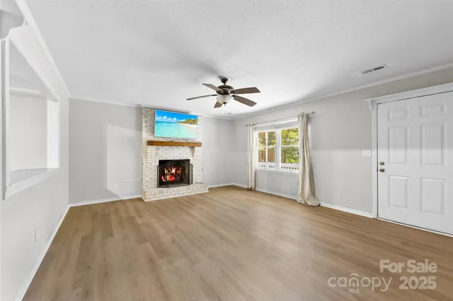 a view of an empty room with window and fireplace