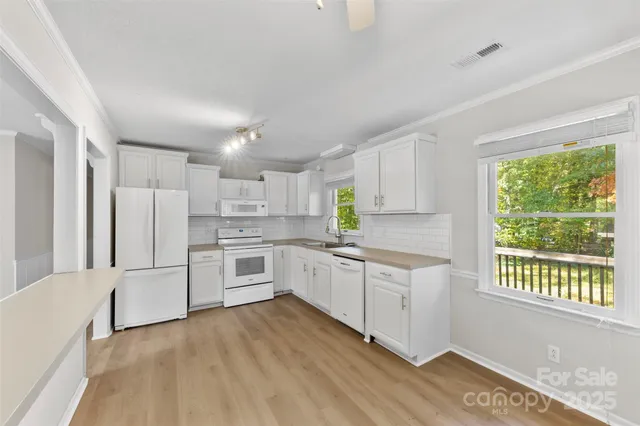 a kitchen with white cabinets and white appliances