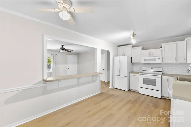 a view of kitchen with wooden floor and electronic appliances