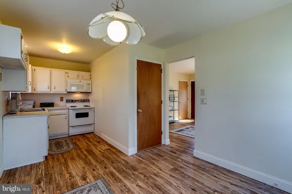 a kitchen with wooden floors and white cabinets