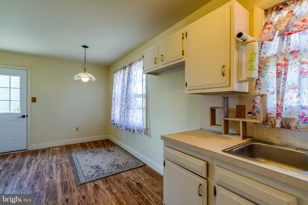 a kitchen with a sink cabinets and wooden floor
