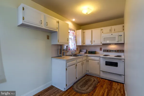 a kitchen with a sink cabinets and a window