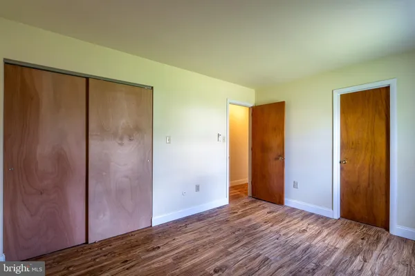 an empty room with wooden floor and closet