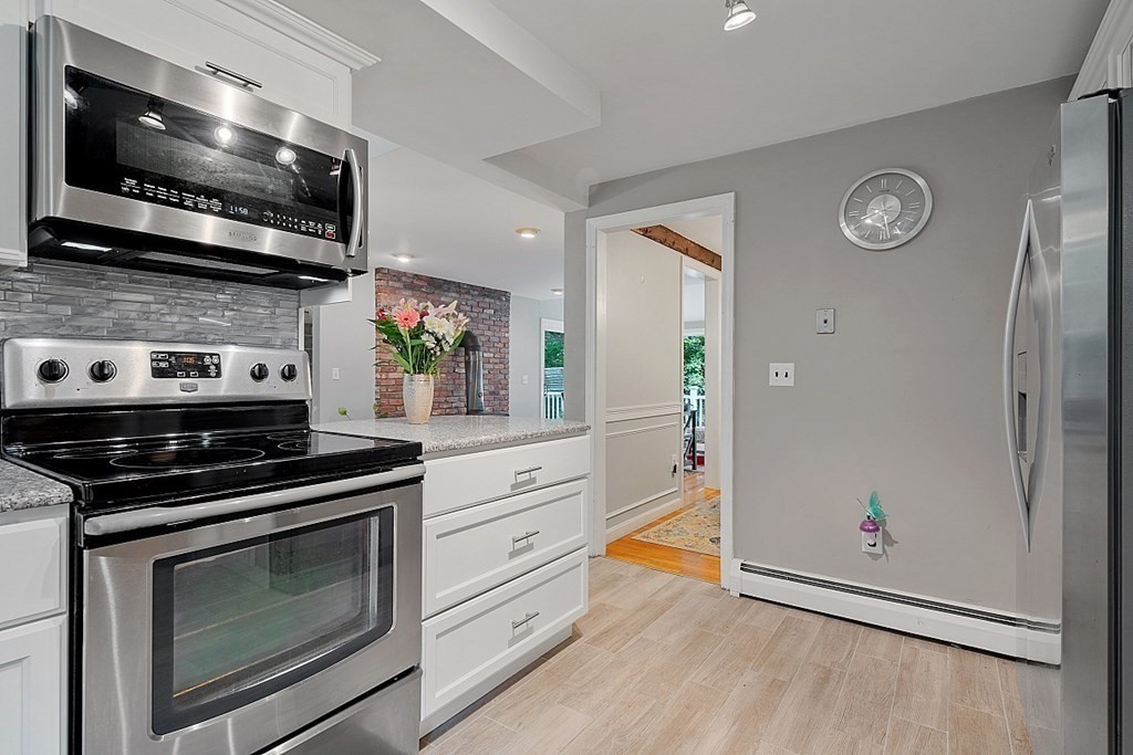 473 Main Street Boxford, MA 01921 - Photo 11 of 42 a kitchen with stainless steel appliances granite countertop a stove microwave and cabinets