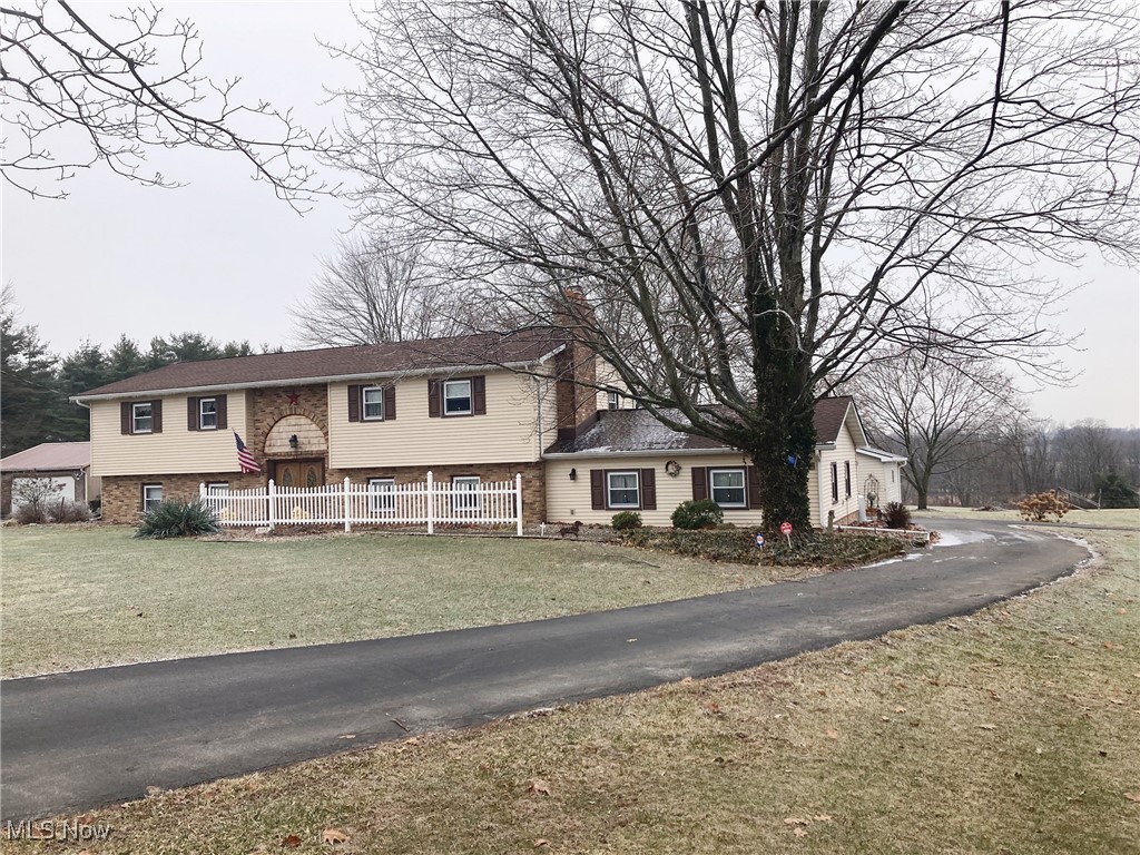 1211 Slater Road Salem, OH 44460 - Photo 1 of 7 Bi-level home featuring brick siding, a chimney, a front yard, and fence
