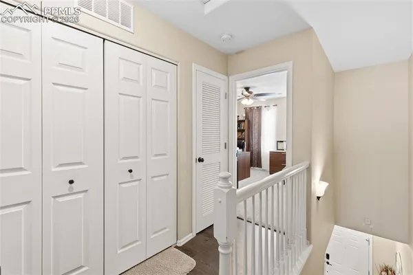 a view of a hallway with wooden floor and entryway