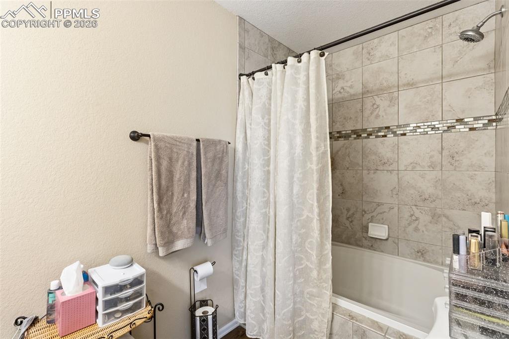 3519 Grey Owl Point Colorado Springs, CO 80916 - Photo 20 of 29 Full bath featuring tiled shower / bath combo and a textured ceiling
