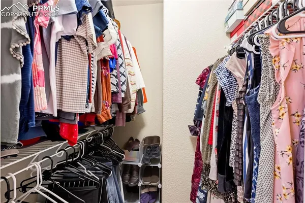 a view of walk in closet with clothes