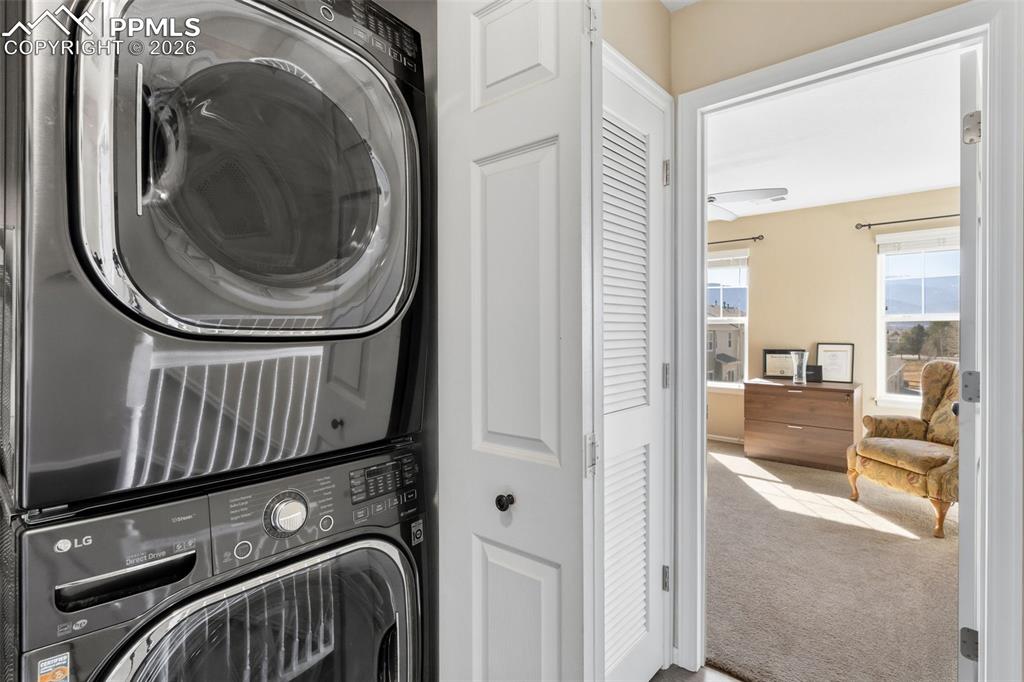 3519 Grey Owl Point Colorado Springs, CO 80916 - Photo 22 of 29 Laundry area with light carpet and stacked washer and dryer