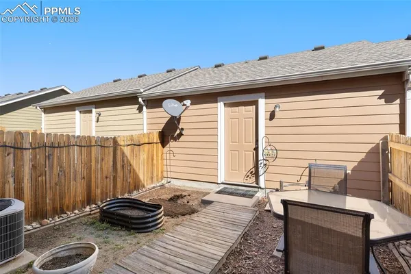 a backyard of a house with chairs and wooden floor