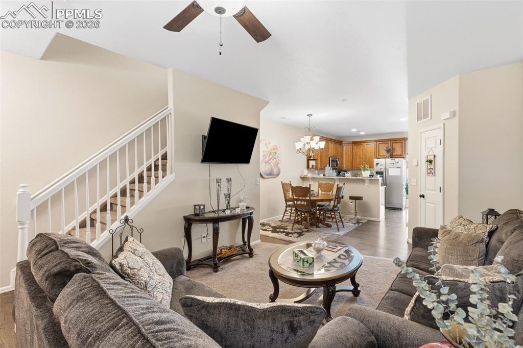 3519 Grey Owl Point Colorado Springs, CO 80916 - Photo 4 of 29 Living area with a ceiling fan, light wood finished floors, and hanging lights