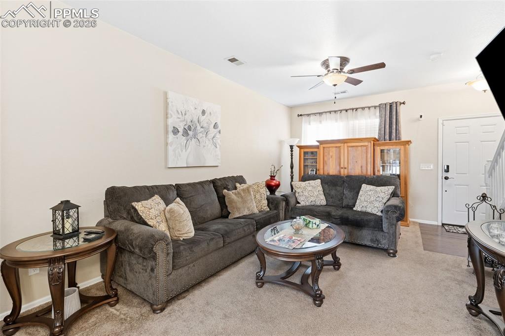 3519 Grey Owl Point Colorado Springs, CO 80916 - Photo 5 of 29 Living room with light colored carpet and ceiling fan