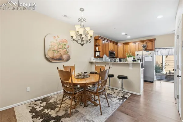 a view of a dining room with furniture a chandelier and wooden floor