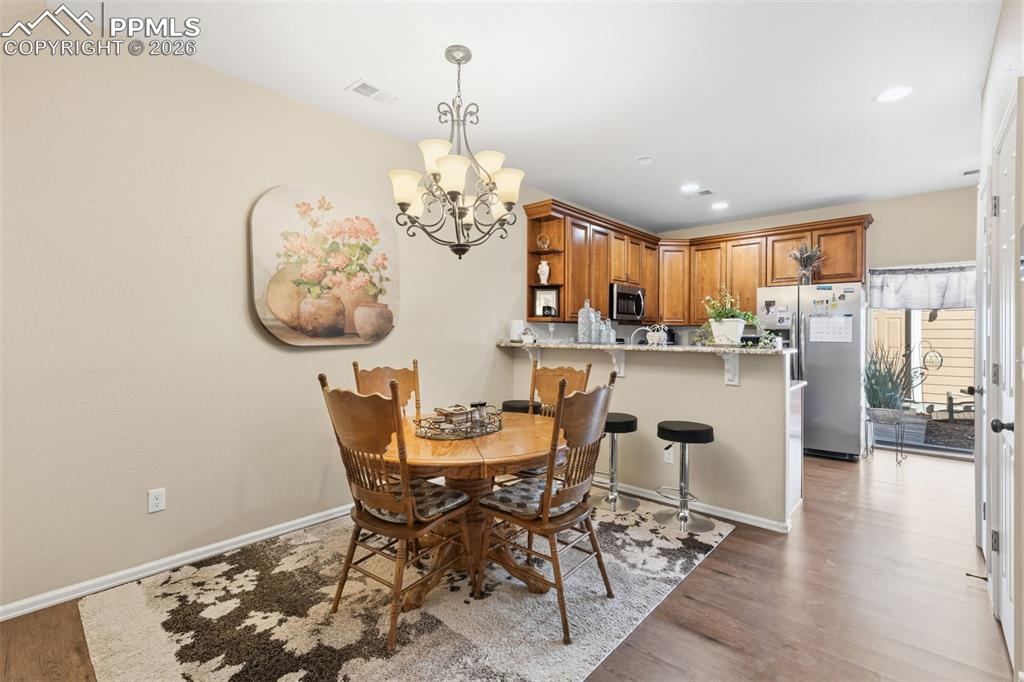 3519 Grey Owl Point Colorado Springs, CO 80916 - Photo 6 of 29 Dining space with dark wood-style flooring and hanging lights