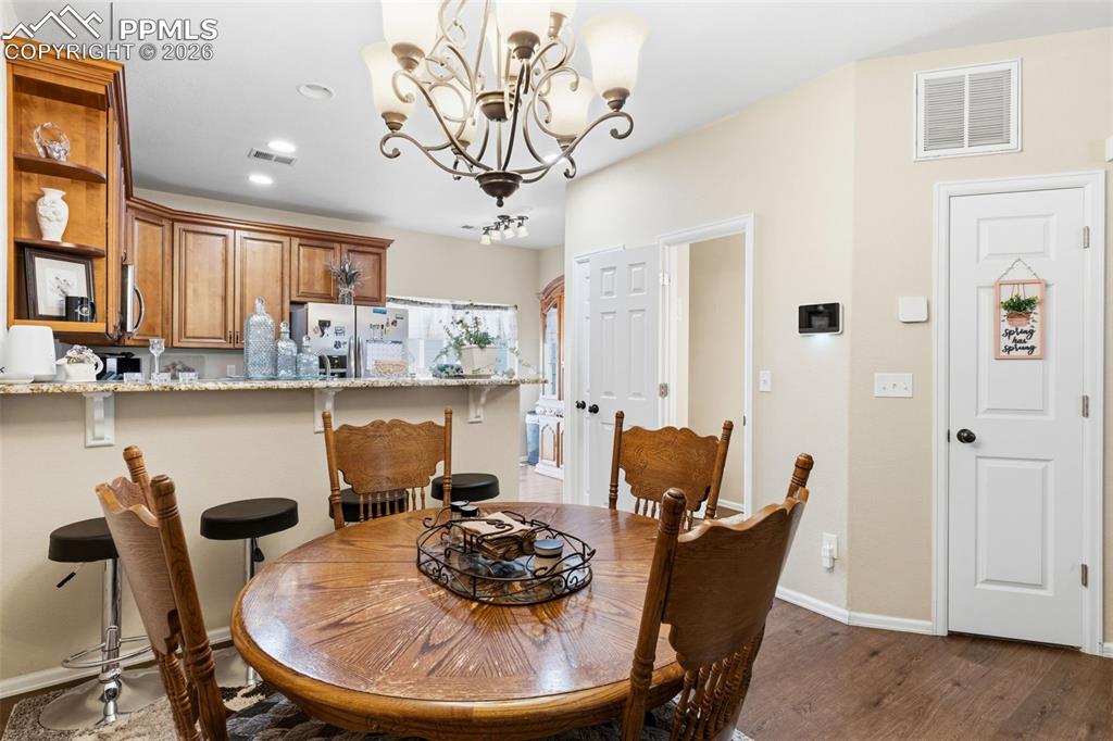 3519 Grey Owl Point Colorado Springs, CO 80916 - Photo 8 of 29 Dining room with hanging lights and dark wood-style flooring