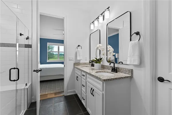a bathroom with a double vanity sink a mirror and bathtub