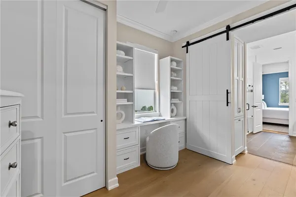 a view of a walk in closet and bedroom with furniture