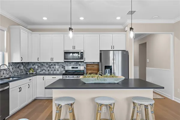 a kitchen with stainless steel appliances a sink stove and refrigerator