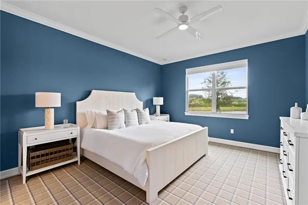 a bedroom with a bed and a lamp on dresser