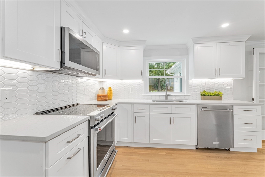 26 Crehore Road Boston, MA 02467 - Photo 11 of 33 a kitchen with granite countertop a sink stainless steel appliances and white cabinets