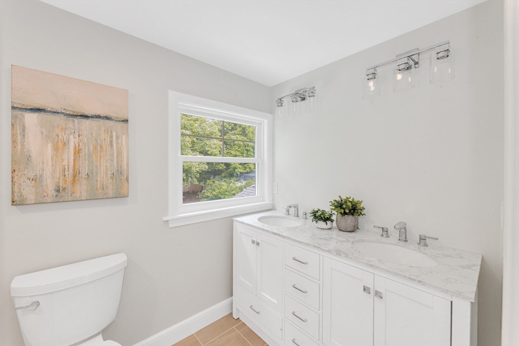 26 Crehore Road Boston, MA 02467 - Photo 19 of 33 a bathroom with a granite countertop sink a toilet and a window