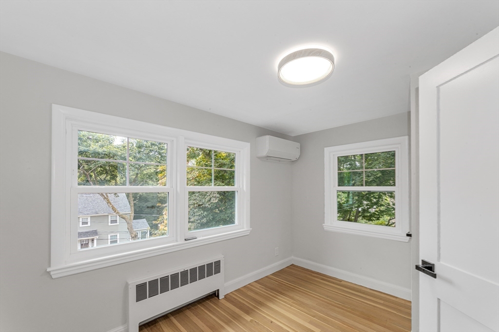 26 Crehore Road Boston, MA 02467 - Photo 23 of 33 an empty room with wooden floor and windows
