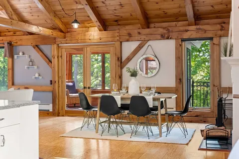 a view of a dining room with furniture a chandelier and wooden floor