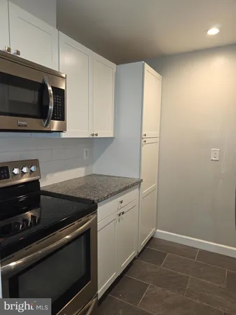 a kitchen with stainless steel appliances granite countertop a sink and a stove