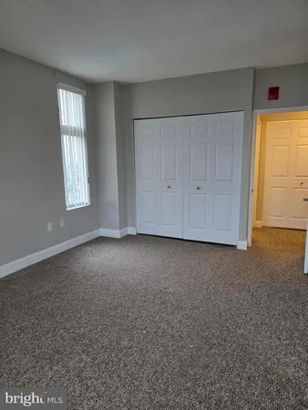 an empty room with windows and closet