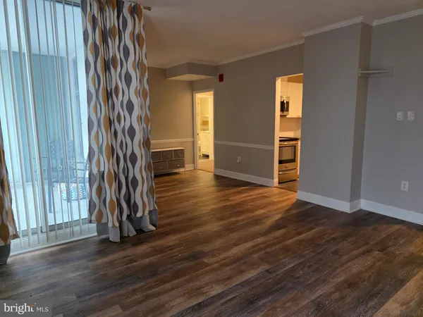 an empty room with wooden floor and a window