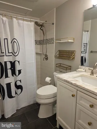 a bathroom with a granite countertop sink toilet and shower