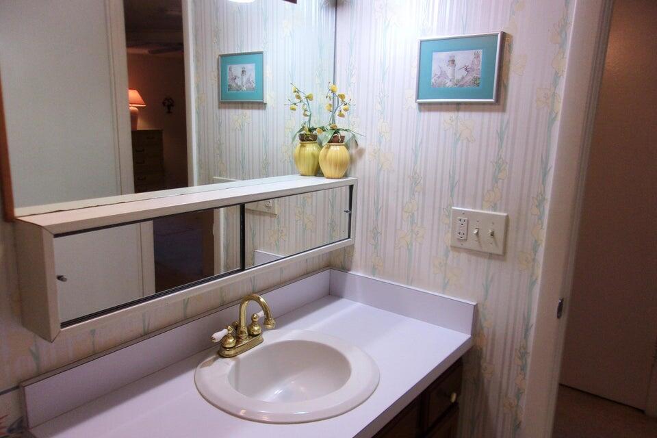 1225 Northwest 21st Street, Unit 3506 Stuart, FL 34994 - Photo 18 of 25 a bathroom with a sink a mirror and vanity