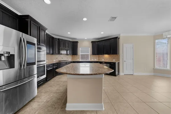 a kitchen with stainless steel appliances granite countertop a sink and a refrigerator